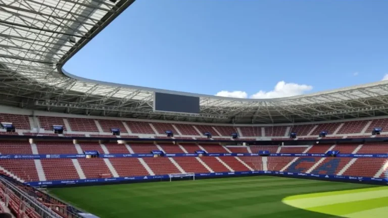 Interior del estadio El Sadar de Pamplona, sede del CA Osasuna, con las gradas rojillas y el césped visto desde la tribuna