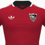 Segunda equipación del Sevilla FC 2026-27 fabricada por Adidas, en color rojo con cuello polo negro, ribetes en beige y logo Trefoil clásico