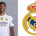 David Alaba con la camiseta del Real Madrid junto al escudo del club blanco