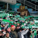 Aficionados del Real Racing Club de Santander en las gradas del estadio El Sardinero con bufandas verdes durante un partido de Segunda División