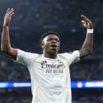 Vinicius Jr con los brazos en alto durante un partido del Real Madrid en el Santiago Bernabéu