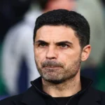 Mikel Arteta, entrenador del Arsenal, en actitud reflexiva en el banquillo durante un partido europeo