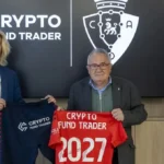 Luis Sabalza, presidente de Osasuna, y Alan Sánchez, fundador de Crypto Fund Trader, posando con la camiseta rojilla con el logo del patrocinador y el número 2027