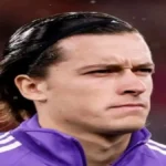 Álvaro Carreras observa desde el banquillo del Real Madrid durante un partido de LaLiga en el Santiago Bernabéu, reflejando su pérdida de estatus en el equipo blanco.