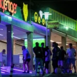 Turistas británicos en la zona de ocio nocturna de Benidorm durante el Mundial de Fútbol 2026, con neones y establecimientos de hostelería al fondo