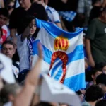 Aficionados del RCD Espanyol en la grada con bandera azul y blanca del club