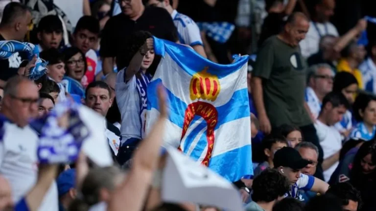 Aficionados del RCD Espanyol en la grada con bandera azul y blanca del club