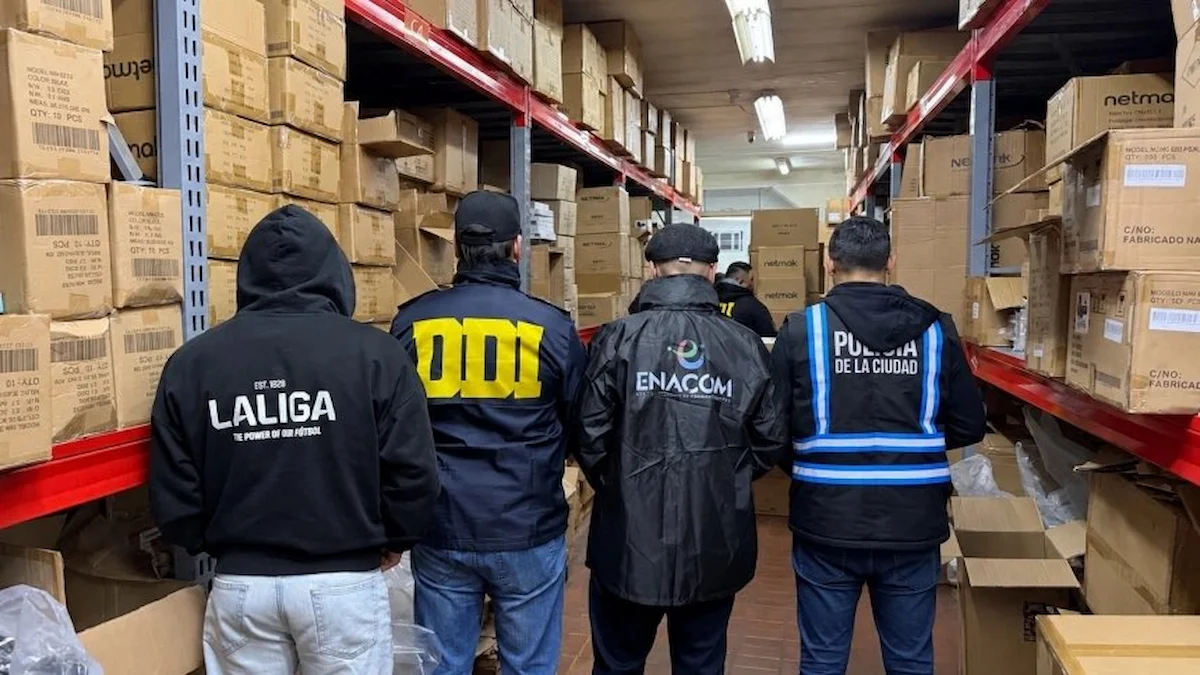 Agentes de ENACOM, DDI y Policía de la Ciudad inspeccionan estantes con cajas de TV Boxes incautados en un almacén durante el operativo antipiratería en Argentina