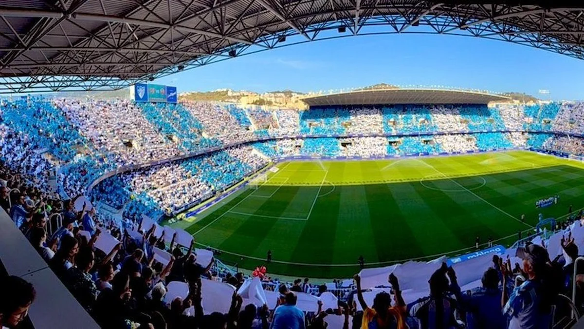 Panorámica interior de La Rosaleda con la grada llena de tifo blanquiazul antes de un partido del Málaga CF