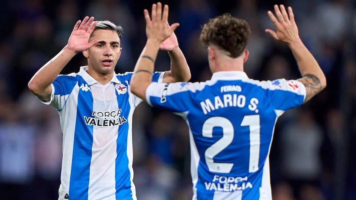 Mario Soriano y el dorsal 21 del Deportivo celebran un gol en el estadio de Riazor con el mensaje Força València en sus camisetas