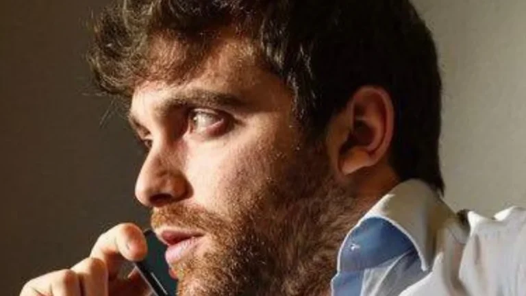 Hombre con traje de camisa blanca habla por teléfono con gesto concentrado, en referencia a la comunicación estratégica en el fútbol