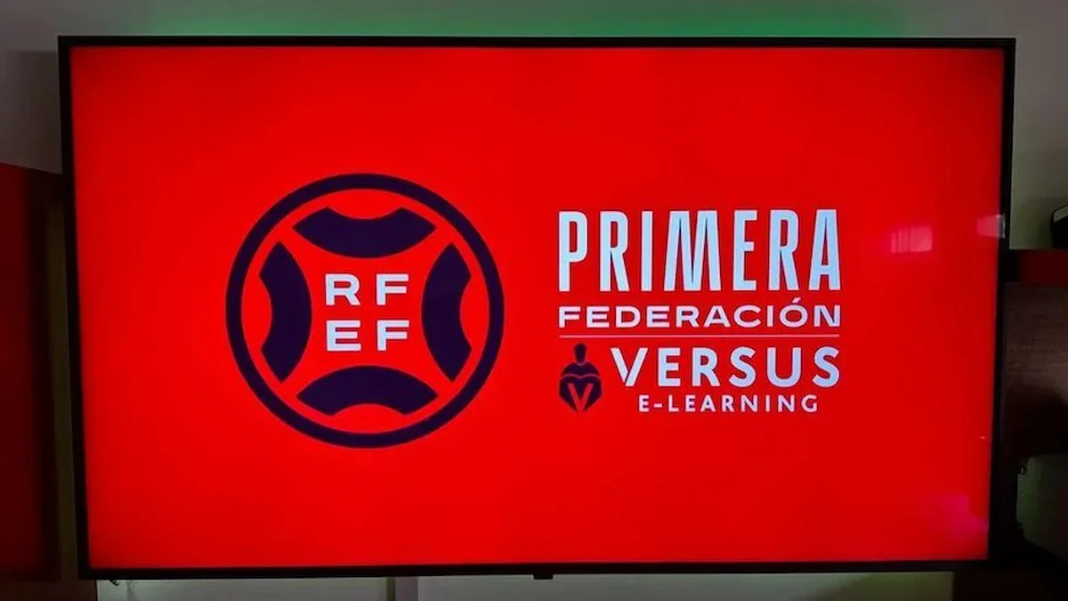 Pantalla de TV con el logo de la RFEF y el rótulo Primera Federación Versus e-Learning sobre fondo rojo