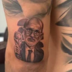Detalle del tatuaje del rostro de Luis de la Fuente con la Copa del Mundo en el brazo de Cucurella