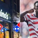 Escaparate de una tienda Domino's junto a Folarin Balogun celebrando un gol con la camiseta de Estados Unidos