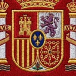 Escudo bordado de la RFEF sobre tela roja con seis estrellas, doradas y plateadas