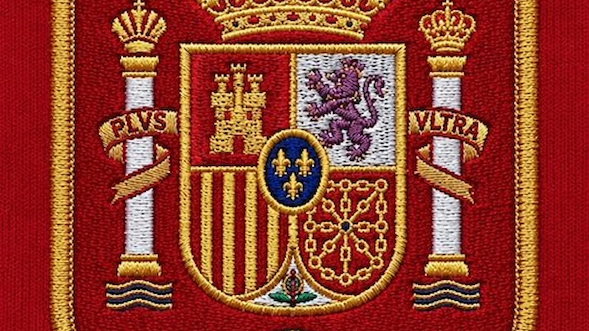 Escudo bordado de la RFEF sobre tela roja con seis estrellas, doradas y plateadas