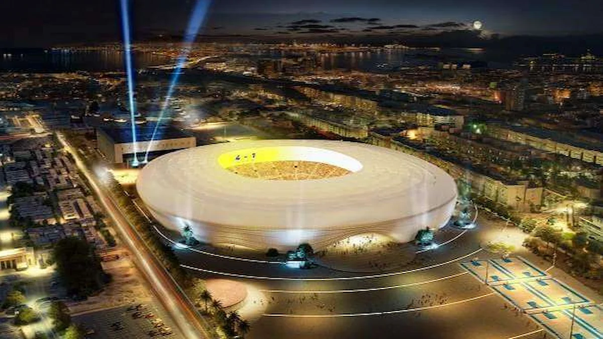 Recreación nocturna del futuro Estadio de Gran Canaria iluminado, con la bahía y la ciudad al fondo