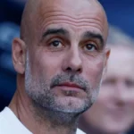 Pep Guardiola observa con gesto serio desde el banquillo antes de un partido