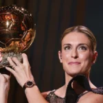 Futbolista femenina levanta un trofeo dorado en una gala de fútbol