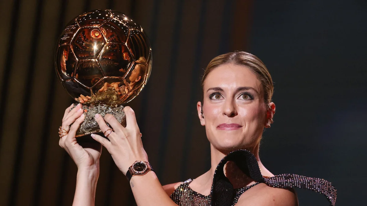 Futbolista femenina levanta un trofeo dorado en una gala de fútbol
