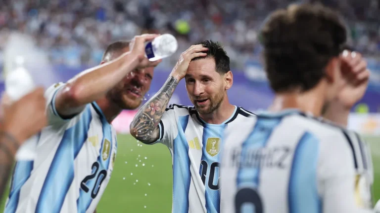 Un compañero moja la cabeza de Leo Messi con agua durante un partido de Argentina