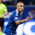Futbolista con camiseta azul del Real Oviedo señalando con el brazo tatuado durante un partido