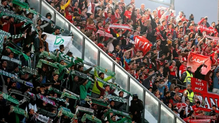 Aficionados del Real Betis y el Sevilla FC agitan bufandas en gradas separadas por una valla