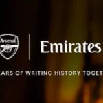 Escudo del Arsenal junto al logotipo de Emirates, con el lema 20 años escribiendo historia juntos