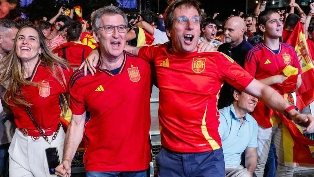 Aficionados con la camiseta de España celebran entre banderas en una fan zone al aire libre