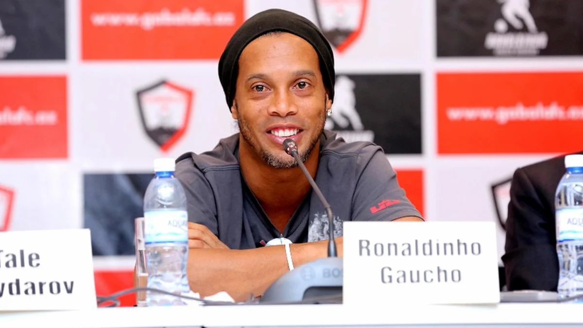 Ronaldinho sonríe en una rueda de prensa sentado ante el micrófono junto al cartel con su nombre