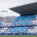 Aficionados del Málaga forman un mosaico azul y blanco en las gradas de La Rosaleda