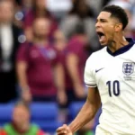 Jude Bellingham celebra un gol con la camiseta de Inglaterra en un estadio con grada azul