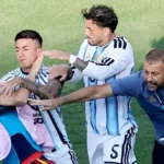 Jugadores argentinos sujetan a un joven en el campo durante la trifulca de la final del Mundial 2026