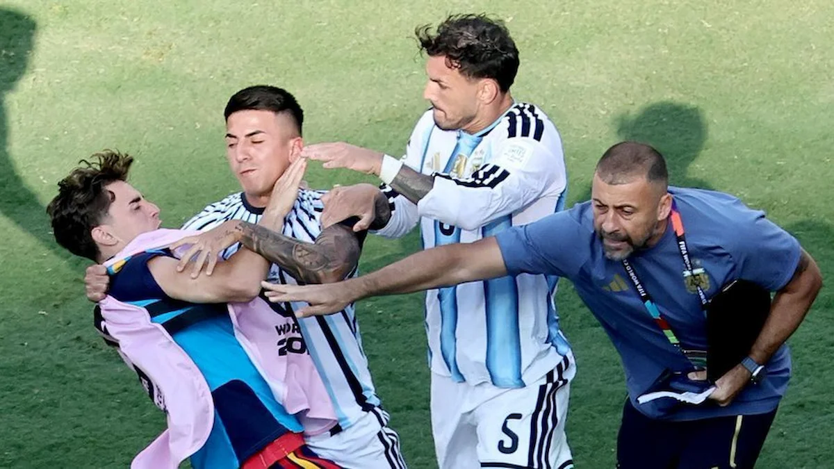 Jugadores argentinos sujetan a un joven en el campo durante la trifulca de la final del Mundial 2026