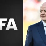 Logotipo de la FIFA junto a Gianni Infantino de traje oscuro y corbata azul en el borde del campo