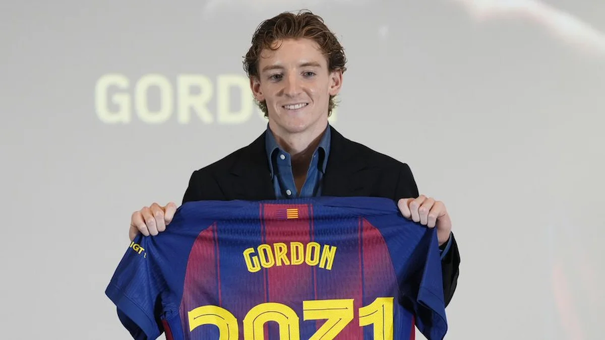 Anthony Gordon sonrie mientras muestra su camiseta del FC Barcelona con su nombre durante su presentacion