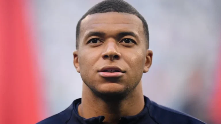 Kylian Mbappé, en primer plano y con gesto serio, antes de un partido con gradas de fondo