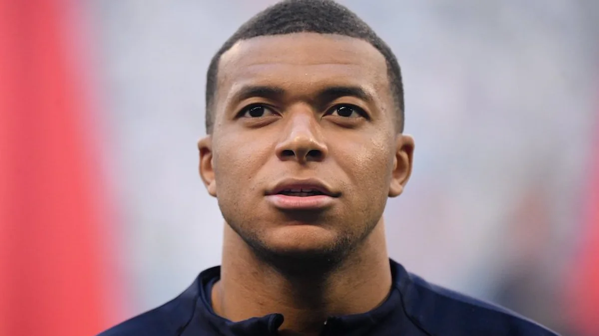 Kylian Mbappé, en primer plano y con gesto serio, antes de un partido con gradas de fondo