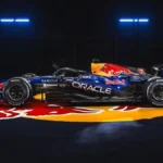 Monoplaza de Fórmula 1 de Red Bull Racing con decoración azul y logos de Oracle y Ford en un estudio oscuro